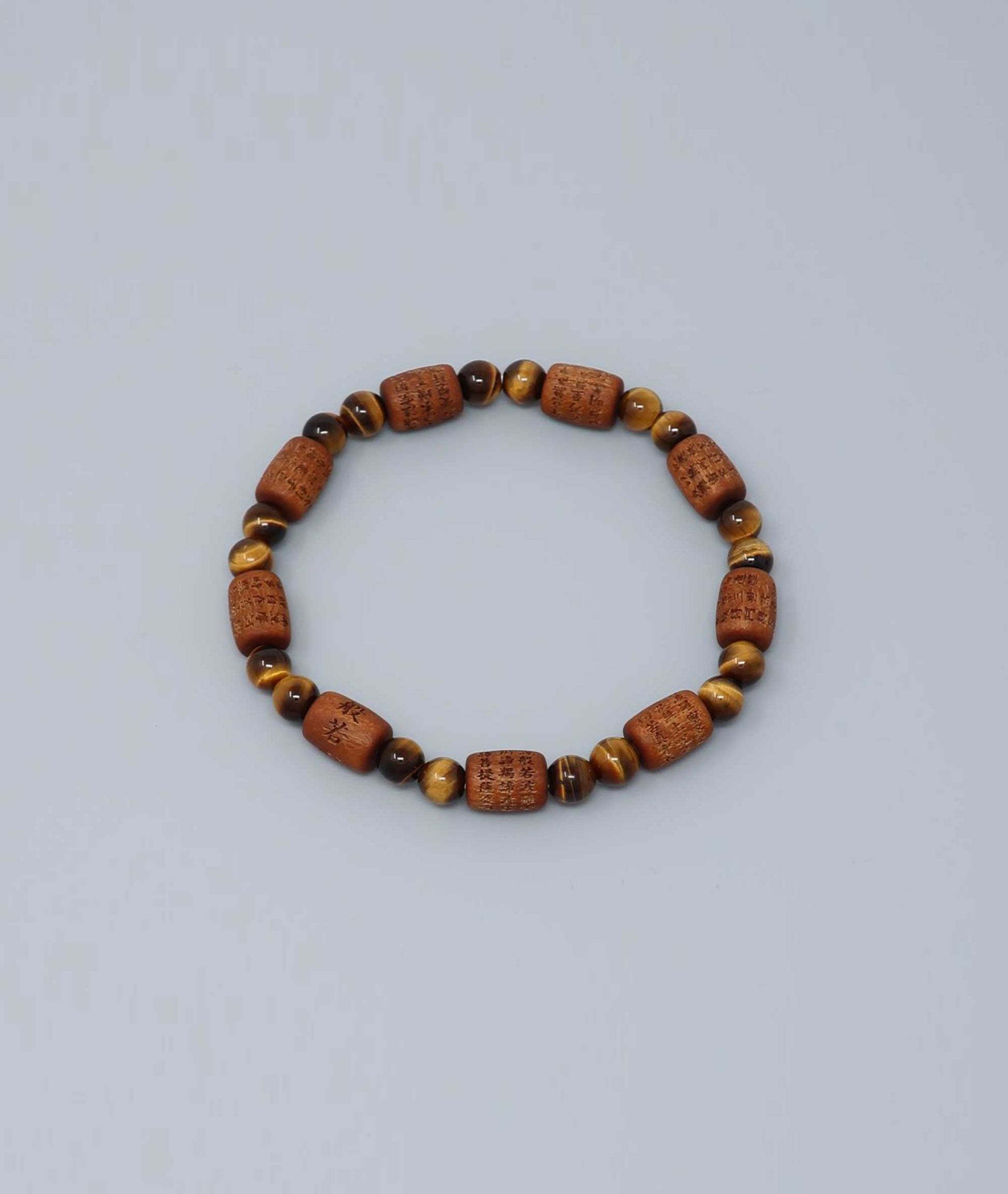 Sandalwood bracelet engraved with the Heart Sutra and accented with a Tiger’s Eye bead—handcrafted for spiritual protection and harmony. Handcrafted in Kyoto Japan Kanbe Juzu, ideal for amulet, yoga, meditation, prayer, or gifting.