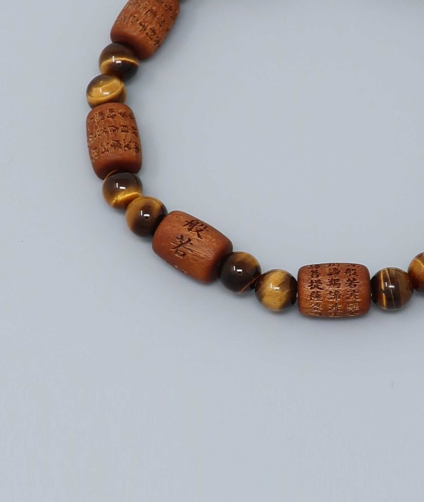 Sandalwood bracelet engraved with the Heart Sutra and accented with a Tiger’s Eye bead—handcrafted for spiritual protection and harmony. Handcrafted in Kyoto Japan Kanbe Juzu, ideal for amulet, yoga, meditation, prayer, or gifting.